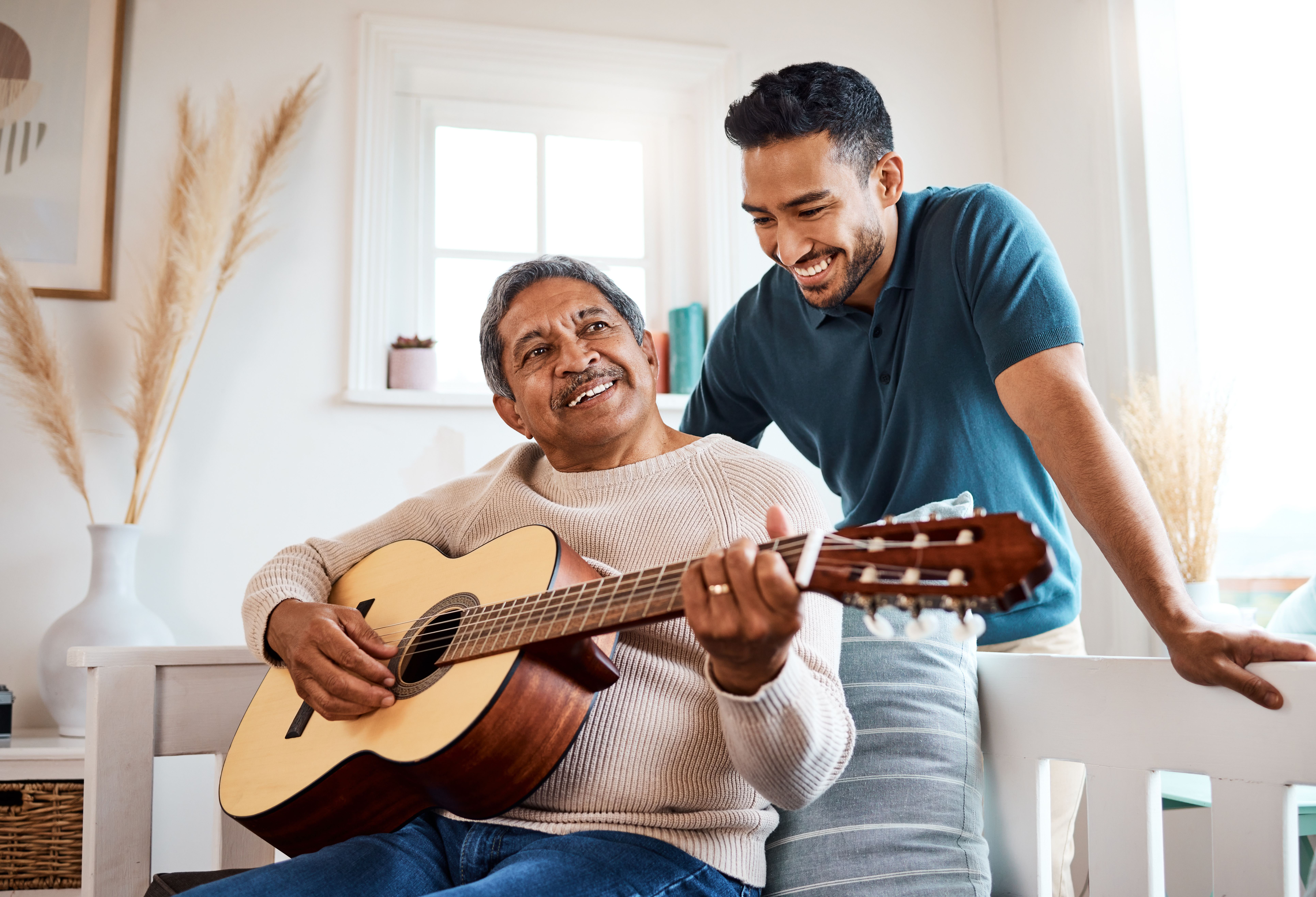 Two men sharing a moment with a guitar